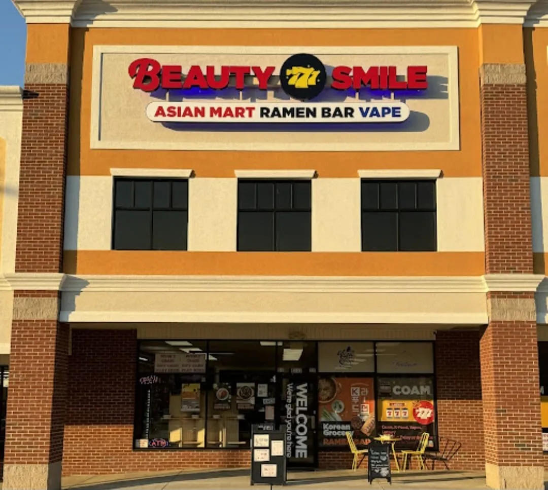 Beauty Smile, Augusta, GA: storefront exterior with sign reading Beauty Smile, Asian Mart Ramen Bar Vape, strip mall building with sidewalk sign and outdoor seating