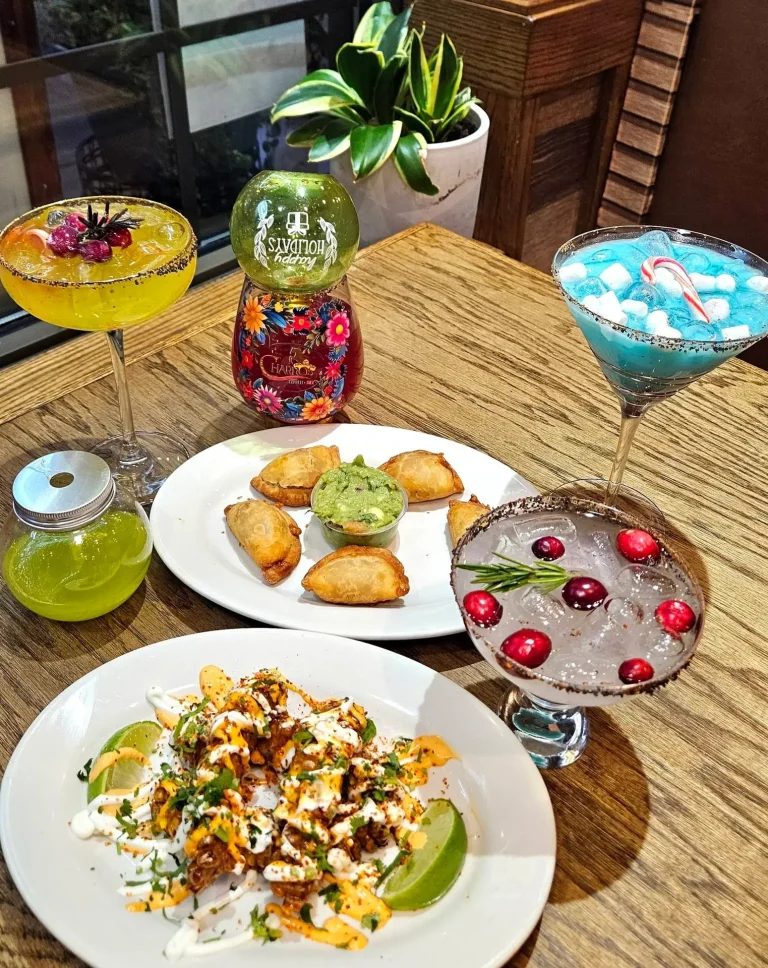 Charro's Express Mex, Evans, GA: mexican restaurant spread: yellow, blue, and cranberry-rimmed margaritas, mini empanadas with guacamole dip, loaded nachos/birria fries with cheese and lime, decorative bottle