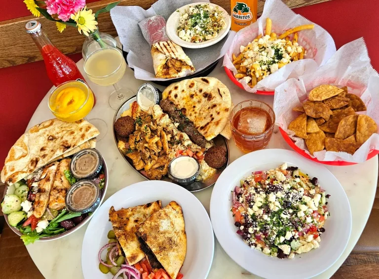 Laziza Mediterranean Grill, Aiken, SC: large Mediterranean food spread: gyro meat and falafel platter with pita and hummus, Greek salad, feta fries, hummus with pita triangles, wraps, chips, and assorted drinks